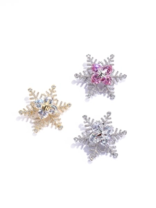 Detailed view of rotating snowflake brooches with gold and silver zircon inlay