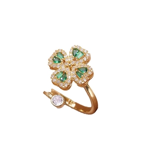 Adjustable golden clover ring with green heart-shaped zircons and white crystals