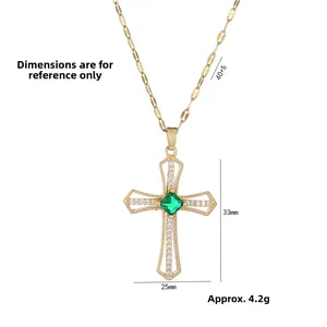 Detail view of gold cross pendant with green square gemstone and white pavé crystals