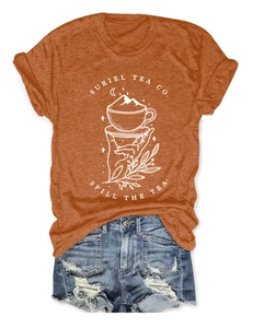 Gros plan d'un t-shirt graphique Suriel Tea Co rouille avec un short en jean bleu usé