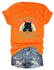 T-shirt orange motif chat crochet et short en jean vieilli posé à plat sur fond blanc