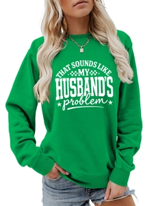 Detail of green crewneck sweatshirt featuring white decorative slogan and ribbed cuffs