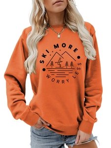 Detail of orange crewneck sweatshirt featuring Ski More Worry Less mountain print texture