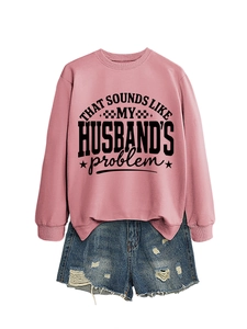 Flat lay of pink crewneck sweatshirt with black slogan print and distressed denim shorts