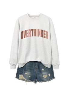 Flat lay of OVERTHINKER grey sweatshirt with distressed blue denim shorts set