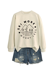Detail of Ski More Worry Less print on beige sweatshirt with distressed denim shorts