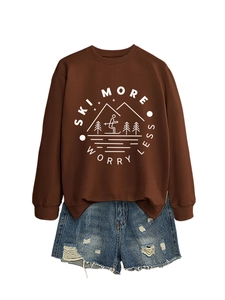 Close-up of brown sweatshirt with ski graphic and distressed denim shorts ensemble