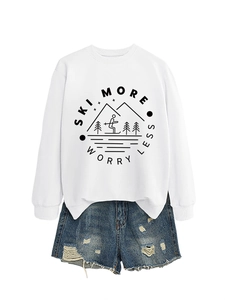 Flat lay of white crewneck sweatshirt with Ski More Worry Less print and denim shorts
