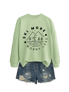 Detail of light green sweatshirt with Ski More Worry Less print and ripped denim shorts