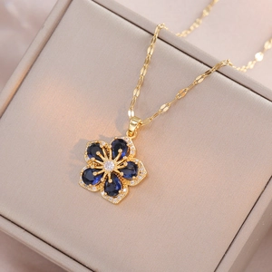 Collier avec pendentif fleur en zircon bleu et chaîne dorée dans une boîte à bijoux