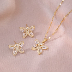Elegant gold butterfly jewelry set with zircon necklace and earrings on silk background