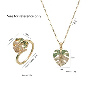 Golden monstera leaf jewelry set with green cubic zirconia including necklace and ring