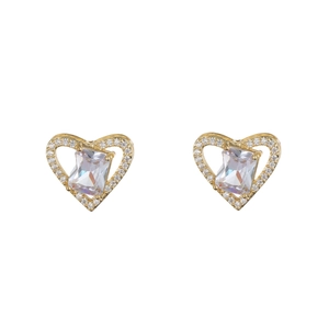 Close-up of golden heart earrings featuring a large zircon center and halo pave setting
