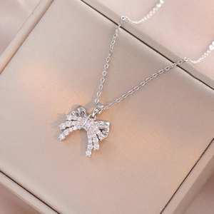 Silver bow pendant necklace with sparkling cubic zirconia on elegant jewelry box