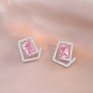 Macro detail of geometric stud earrings with pink zircon stone and silver frame