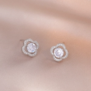 Boucles d'oreilles fleur à quatre pétales avec zircons brillants sur satin