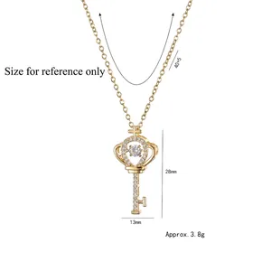 Gold crown key necklace with zircon stones and beating heart pendant on white background