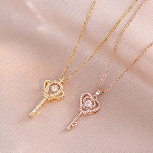 Elegant heart and crown key necklaces in gold and rose gold on pink silk fabric