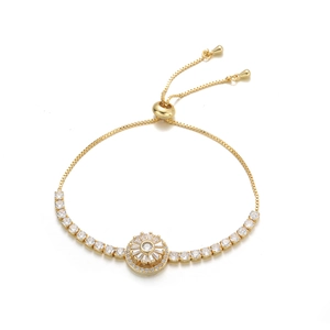 Dettaglio di un bracciale dorato regolabile con charm sole in zircone e chiusura a scorrimento