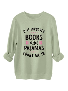 Détail des poignets du sweat vert sauge et slogan imprimé avec motifs de livres et étoiles