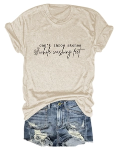 Détail à plat d'un T-shirt beige avec citation florale et short en jean effiloché