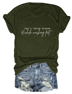 Détail à plat d'un t-shirt graphique vert foncé et d'un short en jean usé à bords effilochés