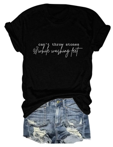 Détail d'un t-shirt noir imprimé et d'un short en jean délavé avec finitions usées