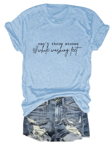 Détail d'un t-shirt bleu clair en coton avec citation et mini-short en jean déchiré