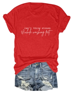 Détail du t-shirt rouge à col rond avec slogan et short en jean vieilli