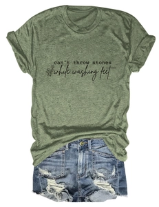 Détail d'un t-shirt vert olive avec imprimé floral noir et texture vintage sur fond blanc