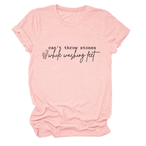 Détail du t-shirt rose en coton montrant le texte imprimé et le motif floral