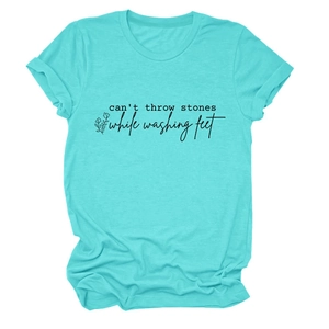 Détail d'un t-shirt vert menthe avec texte imprimé noir et motif floral simple