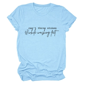 Détail d'un t-shirt bleu clair avec imprimé floral noir et texte sur fond blanc