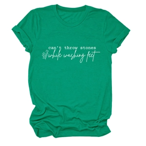 Détail du t-shirt vert à col rond avec slogan blanc et motif floral linéaire