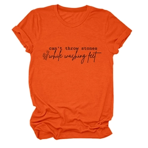 Détail macro des manches retroussées et du tissu en coton orange sur le t-shirt graphique