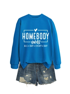 Flat lay of blue Homebody Mode crewneck sweatshirt paired with distressed denim shorts
