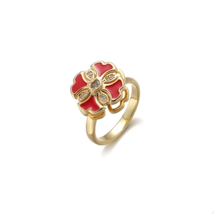 Détail d'une bague dorée avec trèfle à quatre feuilles rouge et accents de zircon