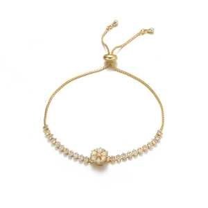 Dettaglio di un bracciale a serpente dorato con fiore di zircone e chiusura regolabile