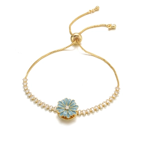 Detail of adjustable gold bracelet featuring a light blue enamel flower with marquise zircons