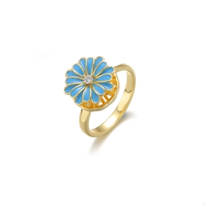 Detailed macro view of gold flower ring with blue enamel petals and zircon center