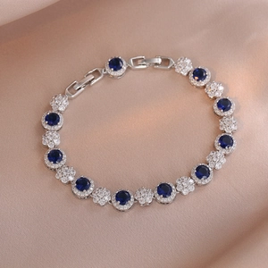 Macro detail of royal blue crystal bracelet with pave zircon flowers on silk fabric
