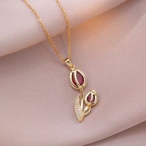 Macro detail of tulip pendant necklace with red zircon stone and gold plating finish