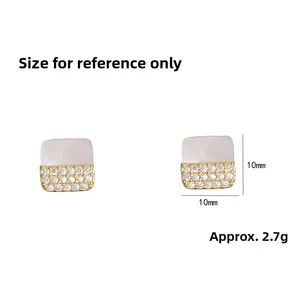 Detailed view of square stud earrings with shell inlay and cubic zirconia stones