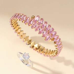 Detail view of gold bangle with pink marquise zircon and silver diamond solitaire ring