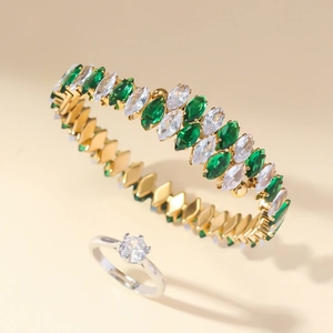 Detail of gold bracelet with marquise green zircon and silver solitaire diamond ring set