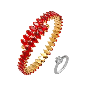 Detail of a gold-finish wrap bracelet with red marquise zircon and a silver solitaire ring