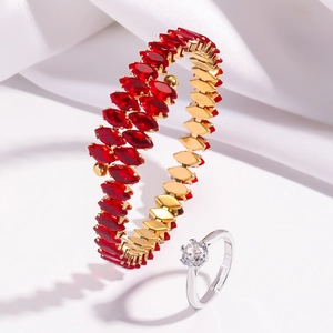 Detail of gold open bangle with red marquise stones and silver round diamond ring