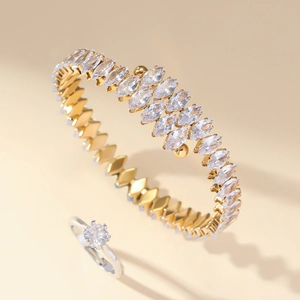 Detail of gold layered open bangle with marquise zircon and silver diamond ring