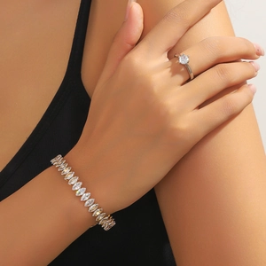 Macro view of six-prong round diamond ring and marquise-cut zircon bracelet