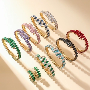 Gold open bangles featuring marquise-cut colorful cubic zirconia in wave settings